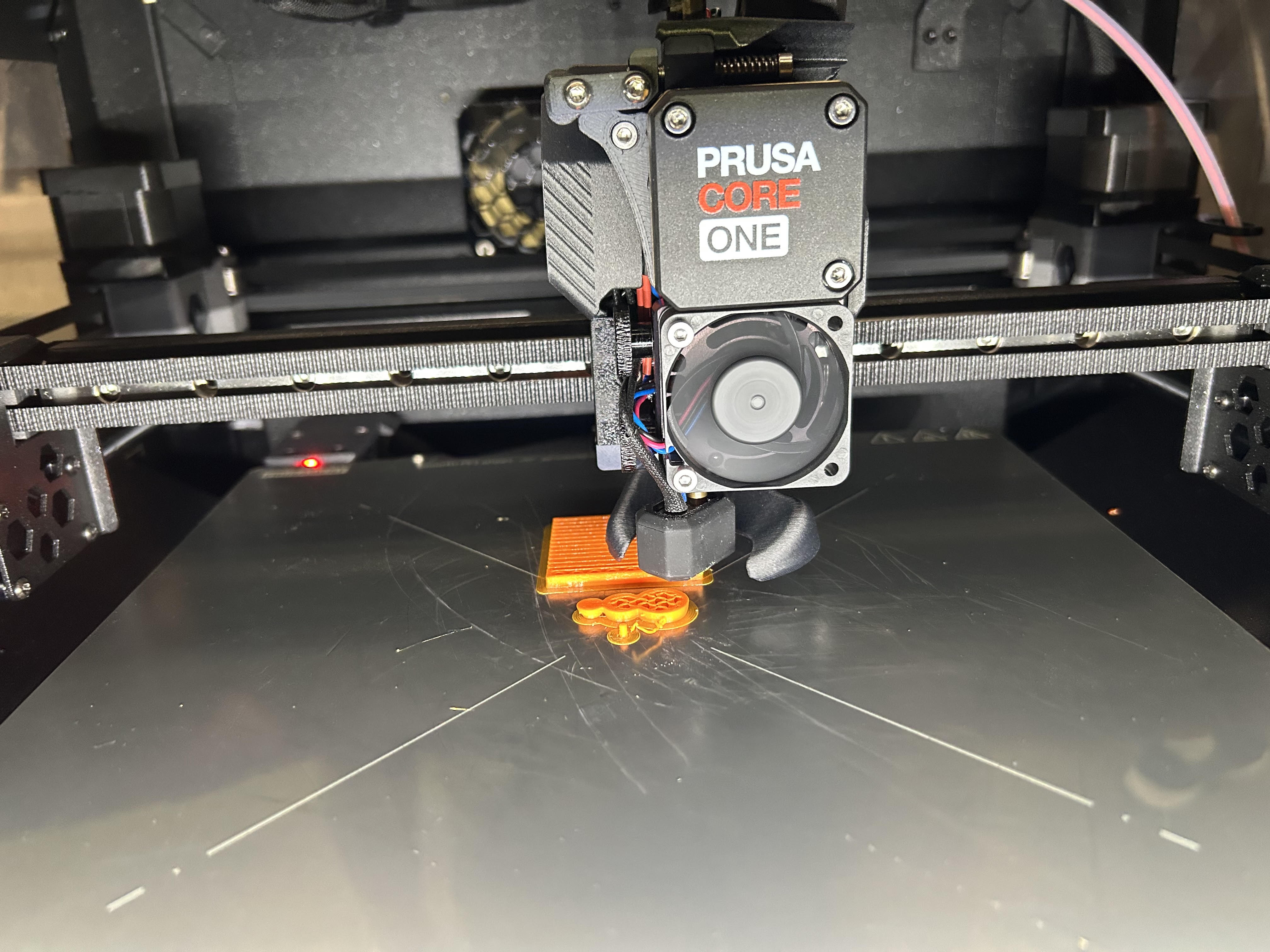 Prusa CORE One mid-print showing the brim and first layers