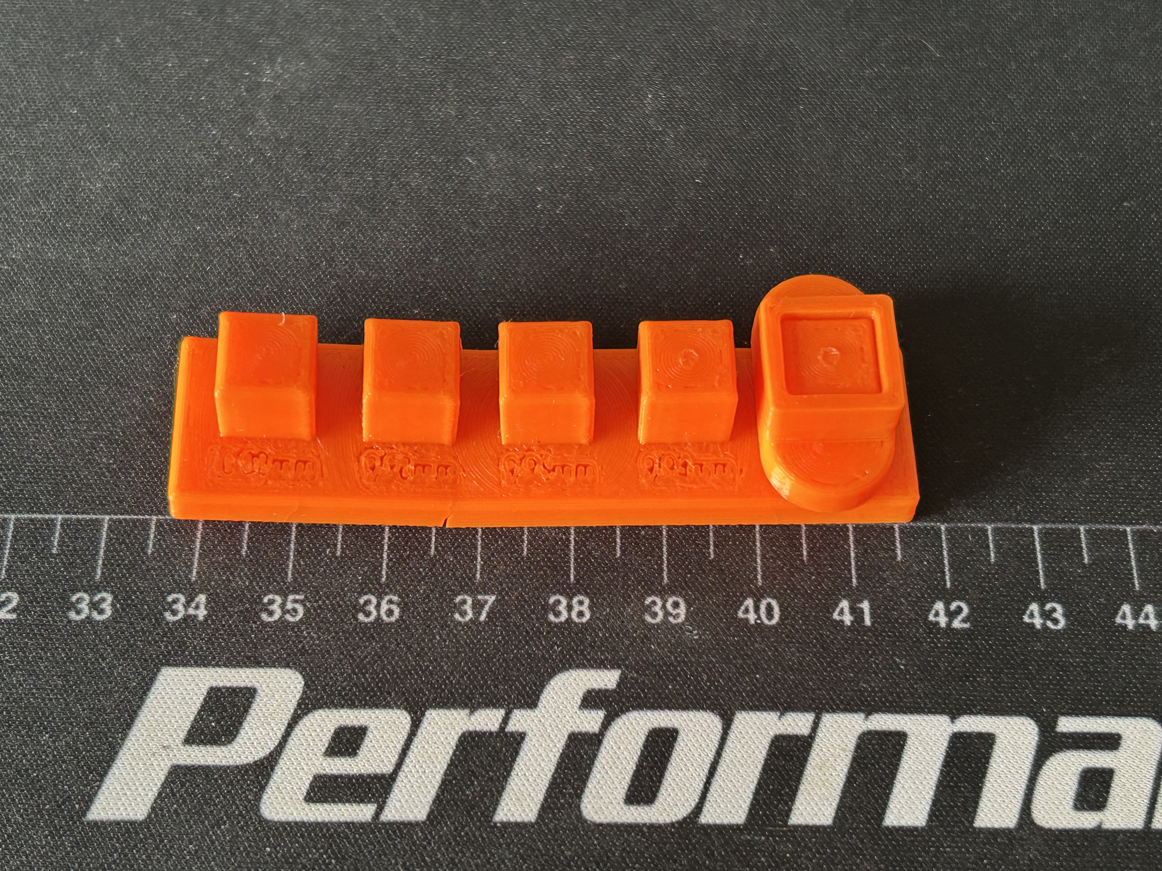 Peg plate with the socket stuck on the end peg and the engraved size labels printed as unreadable blobs